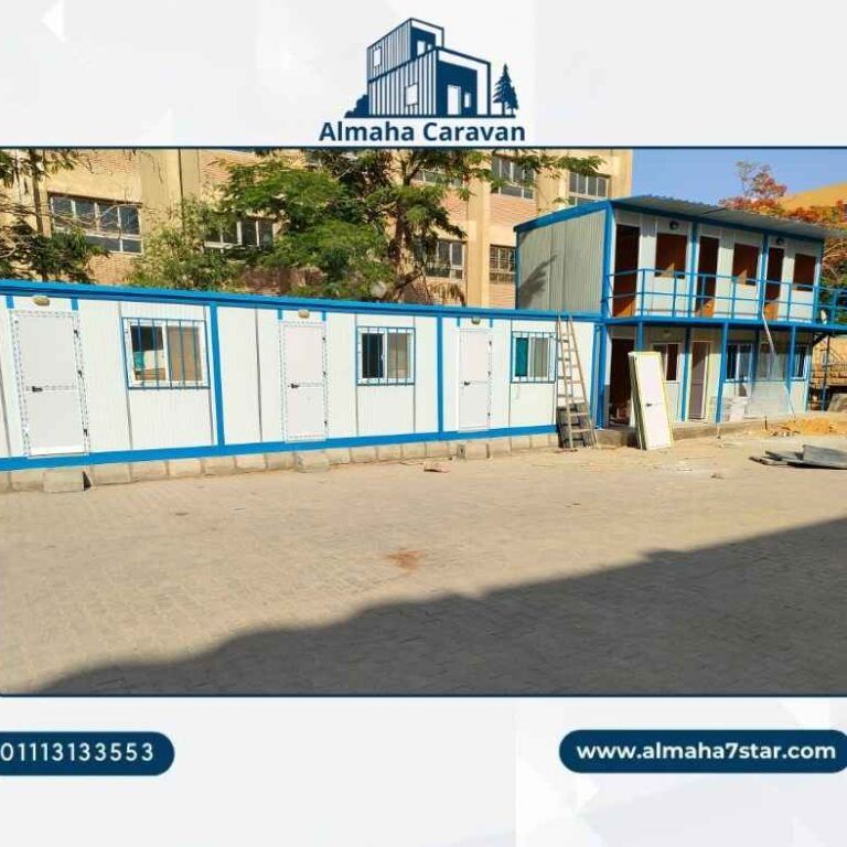 كرفان ساندوتش بانل طويل بإطار أزرق بجوار مبنى كرفانات من دورين في ساحة مبلطة