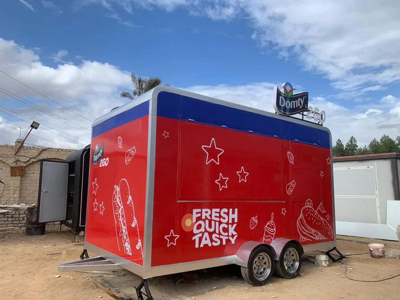 فود تراك مقطورة حمراء بمحورين عليها رسومات نجوم وعبارة FRESH QUICK TASTY