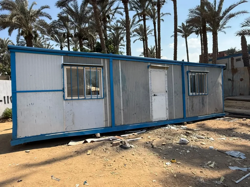 كرفان مستعمل بحالته قبل التجديد بإطار أزرق وباب ونوافذ بحماية حديد