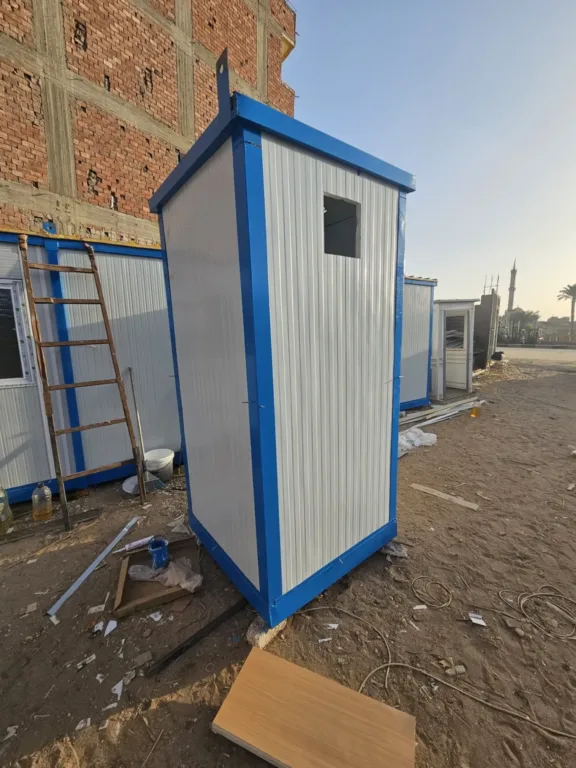 كشك حمام متنقل أبيض وأزرق منصوب في الموقع